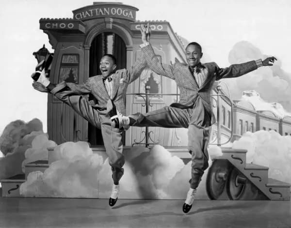 The Nicholas Brothers leaping mid-air in front of a Chattanooga Choo Choo train set